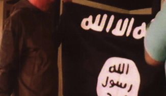 FILE - In this undated file image taken from FBI video and provided by the U.S. Attorney&#x27;s Office in Hawaii on Thursday, July 13, 2017, Army Sgt. 1st Class Ikaika Kang holds an Islamic State group flag after allegedly pledging allegiance to the group at a house in Honolulu. On Tuesday, Dec. 4, 2018, Kang is scheduled to be sentenced for trying to help the Islamic State group. (FBI/U.S Attorney&#x27;s Office, District of Hawaii via AP, File)