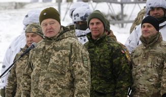 Ukrainian President Petro Poroshenko, second left, addresses Ukrainian soldiers as Canadian Army Lieutenant General Jean-Marc Lanthier stands at center, and commander of U.S. Army in Europe Christopher Cavoli stands right, during military drills in base Honcharivske, Chernihiv region, Ukraine, Monday, Dec. 3, 2018. Ukraine’s president announced a partial call-up of reservists for training amid tensions with Russia, saying Monday that the country needs to beef up its defenses to counter the threat of a Russian invasion. (AP Photo/Efrem Lukatsky)