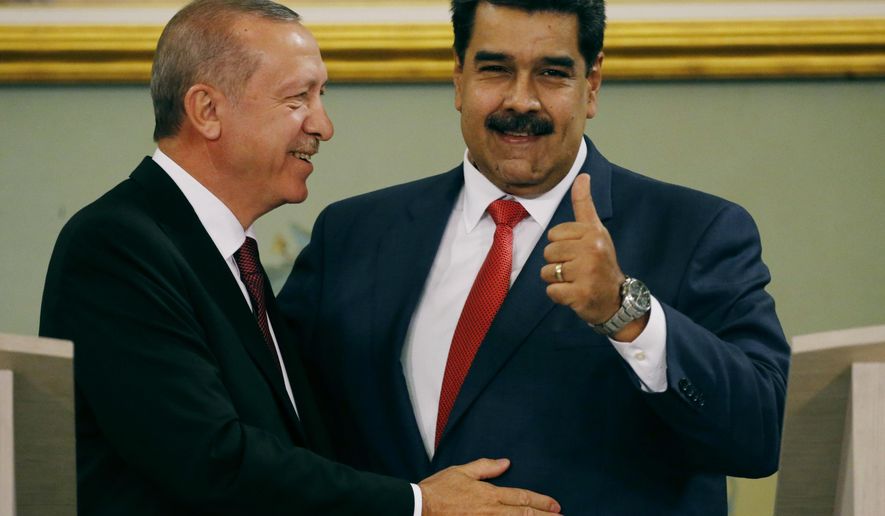 Venezuela's President Nicolas Maduro gives a thumbs up next to Turkey's President Recep Tayyip Erdogan after a joint press conference at Miraflores presidential palace in Caracas, Venezuela, Monday, Dec. 3, 2018. Recep Tayyip Erdogan is on a one-day official visit after attending the G20 in Argentina. (AP Photo/Ariana Cubillos)