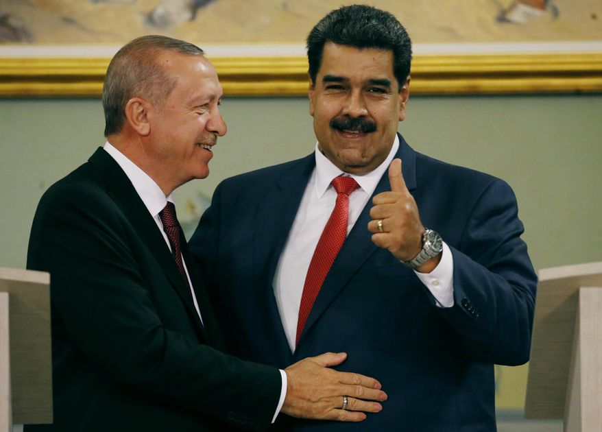 Venezuela's President Nicolas Maduro gives a thumbs up next to Turkey's President Recep Tayyip Erdogan after a joint press conference at Miraflores presidential palace in Caracas, Venezuela, Monday, Dec. 3, 2018. Recep Tayyip Erdogan is on a one-day official visit after attending the G20 in Argentina. (AP Photo/Ariana Cubillos)