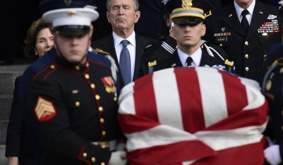 Former President George W. Bush and former first lady Laura Bush, left, follow the casket of former President George H.W. Bush as it is carried out following a State Funeral at the National Cathedral in Washington, Wednesday, Dec. 5, 2018.(AP Photo/Susan Walsh)
