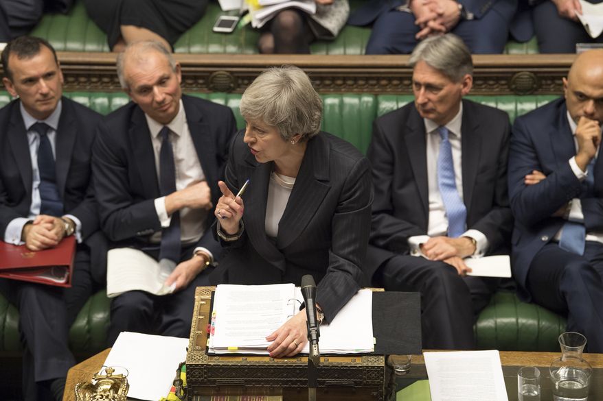 Britain&#39;s Prime Minister Theresa May, centre, gives a reply to lawmakers during the scheduled Prime Minister&#39;s Questions time, in the House of Commons, London, Wednesday Dec. 5, 2018. Britains House of Commons opened round two Wednesday in a bruising battle between lawmakers and Prime Minister Theresa May&#39;s government over Britain&#39;s Brexit split with the EU. (UK Parliament, Mark Duffy via AP)