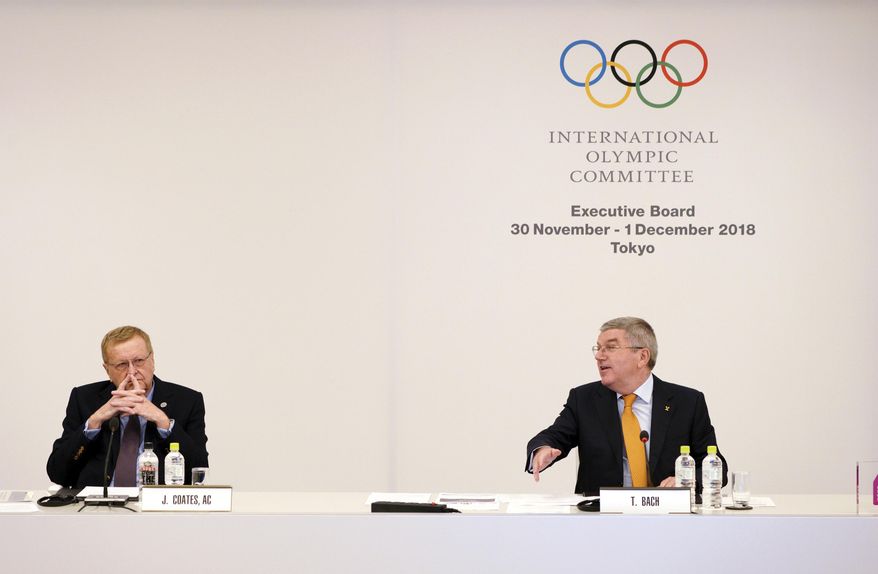 International Olympic Committee (IOC) President Thomas Bach, right, gestures to John Coates, left, chairman of the IOC Coordination Commission for the 2020 Tokyo Olympics and Paralympics, shake hands prior to an IOC Executive Board meeting Saturday, Dec. 1, 2018, in Tokyo. The IOC said boxing will take place at the 2020 Tokyo Olympics. But exactly who runs the tournament and the details of qualifying are up in the air because of charges of corruption and malfeasance surrounding the boxing federation that runs the sport at the Olympics. (AP Photo/Eugene Hoshiko)