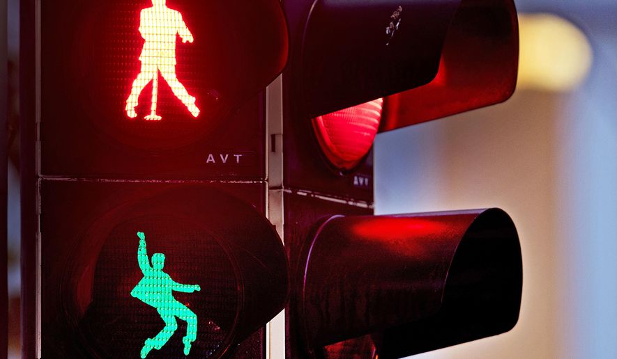 Walking figures depicting late US rock and roll legend Elvis Presley appear on a traffic light switching from green to red in Friedberg near Frankfurt, Germany, Thursday, Dec. 6, 2018. Presley served in Friedberg from October 1958 to March 1960 as a soldier in the US Armed Forces.( AP Photo/Michael Probst)