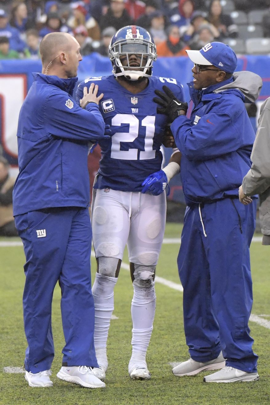 FILE - In this Dec. 2, 2018, file photo, New York Giants strong safety Landon Collins (21) is assisted by trainers during the first half of an NFL football game against the Chicago Bears, in East Rutherford, N.J. Giants safety and leading tackler Landon Collins is going to miss Sunday's game against Washington with a shoulder injury that may require surgery. Coach Pat Shurmur confirmed Wednesday that Collins will be out Sunday and that his injury probably will require surgery.(AP Photo/Bill Kostroun, File)