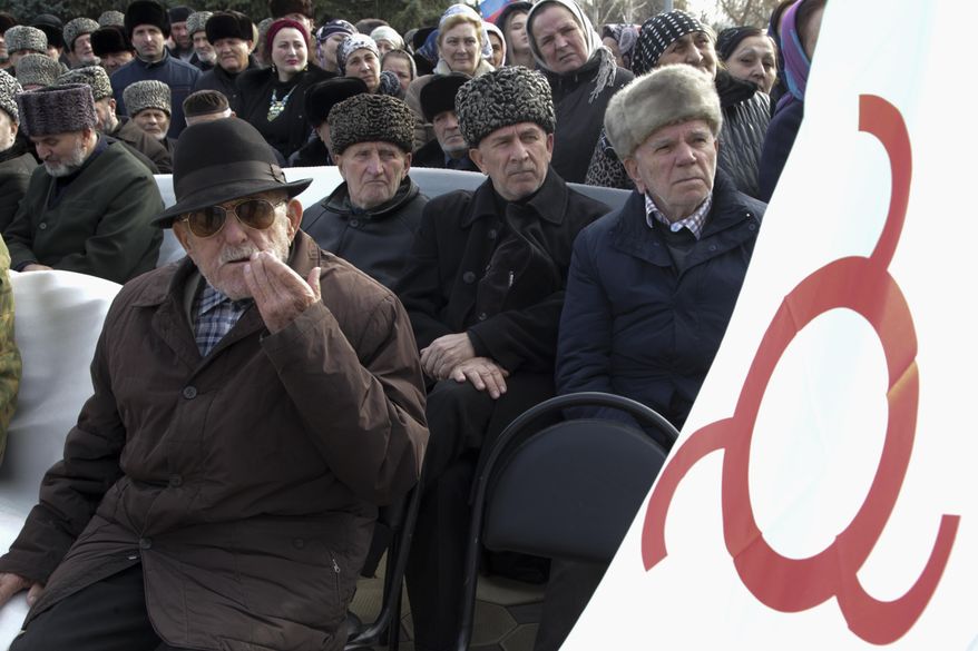 FILE - In this Tuesday, Nov. 27, 2018 file photo, local people with a Ingushetia region flag attend a protest against the new land swap deal agreed by the heads of the Russian regions of Ingushetia and Chechnya, in Ingushetia's town Nazran, Russia. Russia's highest court on Thursday Dec. 6, 2018, upheld a land swap deal in the North Caucasus which caused large-scale protests. (AP Photo/Musa Sadulayev, File)