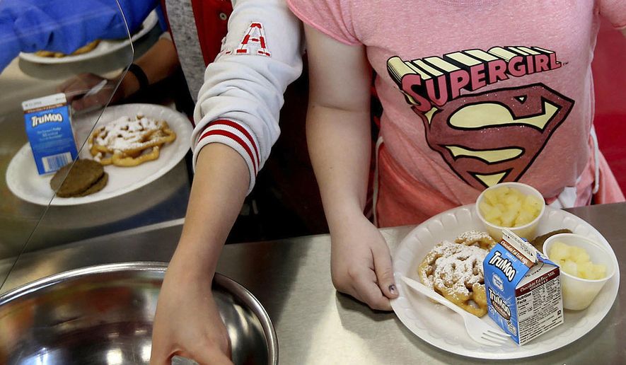 FILE - In this Friday, May 19, 2017 file photo, students line up for lunch at a middle school in Sandy, Utah. On Thursday, Dec. 6, 2018, the U.S. Department of Agriculture announced the scaling back contested school lunch standards implemented under the Obama administration, including one that required only whole grains be served. (Laura Seitz/The Deseret News via AP)