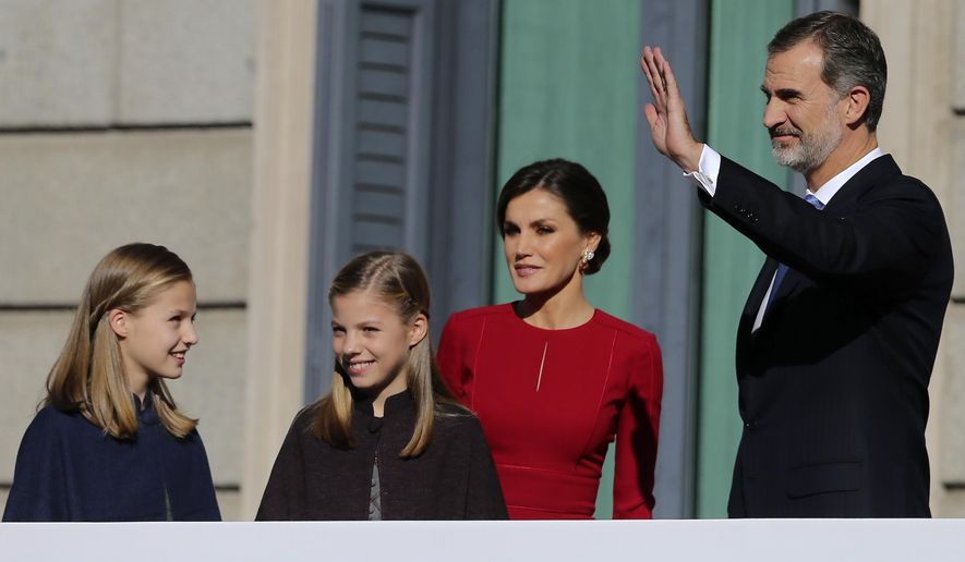 Spain's King Felipe VI and his wife Queen Letizia wave to the crowd with their daughters Princess Leonor, left, and Princess Sofia after their arrival for celebrations of the 40th anniversary of the Spanish Constitution at the Spanish parliament, in Madrid, Spain, on Thursday, Dec. 6, 2018. (AP Photo/Andrea Comas)