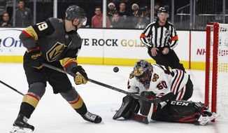 Chicago Blackhawks goaltender Corey Crawford (50) blocks a shot by Vegas Golden Knights right wing Reilly Smith (19) during the second period of an NHL hockey game Thursday, Dec. 6, 2018, in Las Vegas. (AP Photo/John Locher)