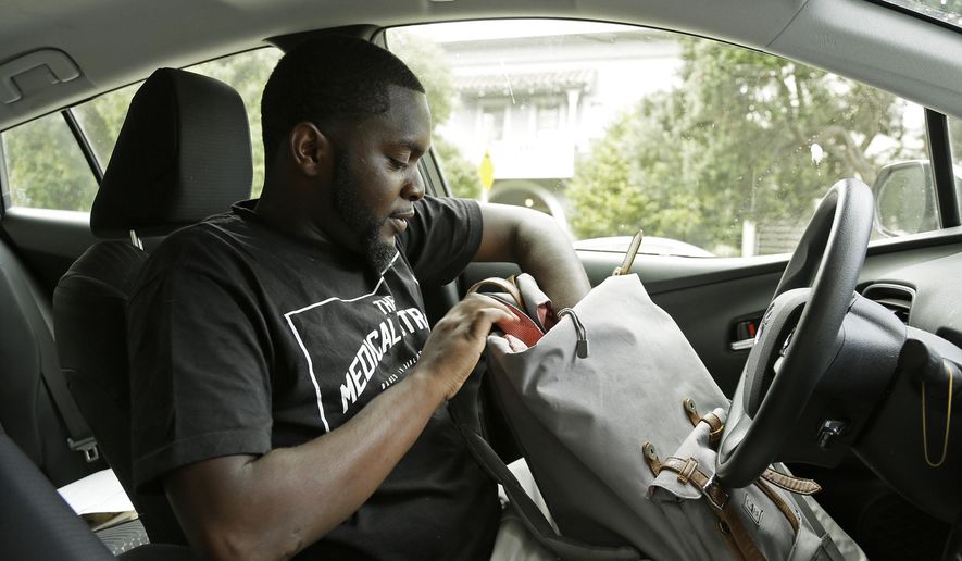 FILE - In this May 11, 2017, file photo, Andre Shavers, who runs a marijuana delivery business, checks his delivery bag in Oakland, Calif. Three California agencies released proposed regulations Friday, Dec. 7, 2018, for the state's marijuana industry including deliveries that will become permanent next month after state lawyers finish their review of them. Law enforcement groups and cities with marijuana bans unsuccessfully fought against it. (AP Photo/Eric Risberg,File)