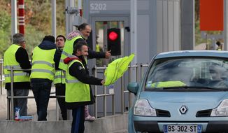 A demonstrator holds a yellow jacket as he protests at the toll gates on motorway at Biarritz southwestern France, Thursday, Dec.6, 2018. Paris police and store owners are bracing for new violence at protests Saturday, despite President Emmanuel Macron&#x27;s surrender over a fuel tax hike that unleashed weeks of unrest. (AP Photo/Bob Edme)