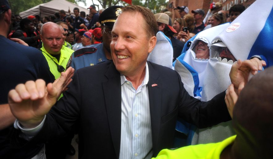 FILE - In this Oct. 24, 2015, file photo, Ole Miss Rebels head coach Hugh Freeze walks through fans on the way to the stadium in Oxford, Miss. Liberty has hired former Mississippi coach Hugh Freeze to lead its football program. A person familiar with the situation told The Associated Press that the Flames have tabbed Freeze as their next coach. The person spoke to the AP on the condition of anonymity because neither the school nor Freeze has publicly announced the decision. Liberty has scheduled a news conference to "name Liberty's next head football coach" for Friday afternoon, Dec. 7, 2018. (Bruce Newman/The Oxford Eagle via AP, File)