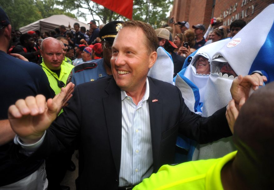 FILE - In this Oct. 24, 2015, file photo, Ole Miss Rebels head coach Hugh Freeze walks through fans on the way to the stadium in Oxford, Miss. Liberty has hired former Mississippi coach Hugh Freeze to lead its football program. A person familiar with the situation told The Associated Press that the Flames have tabbed Freeze as their next coach. The person spoke to the AP on the condition of anonymity because neither the school nor Freeze has publicly announced the decision. Liberty has scheduled a news conference to "name Liberty's next head football coach" for Friday afternoon, Dec. 7, 2018. (Bruce Newman/The Oxford Eagle via AP, File)