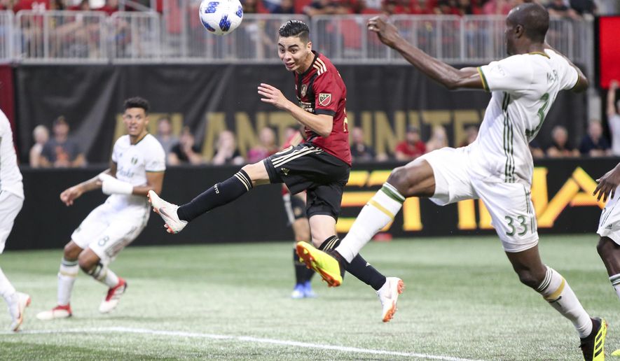 File - In this June 24, 2018, file photo, Atlanta United midfielder Miguel Almiron (10) has a shot defended by Portland Timbers defender Larrys Mabiala (33) in the second half of an MLS soccer match in Atlanta. Before an expected crowd of more than 70,000, Atlanta United will host the Portland Timbers in the MLS Cup championship game Saturday, Dec. 8, 2018. (AP Photo/Brett Davis, File)