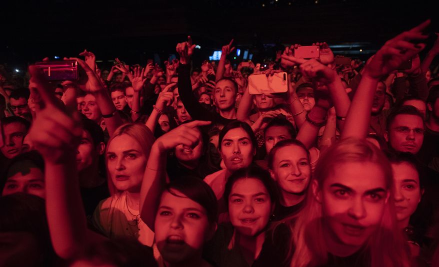 In this photo taken on Monday, Dec. 26, 2018, people cheer during a concert in support of rapper Husky, in Moscow in Moscow, Russia. In recent months, Russian artists have experienced a spike in pressure from the authorities, with a string of concert cancellations and arrests that have brought an outcry from critics who see it as the latest expression of censorship against Russian musicians. (AP Photo/Pavel Golovkin)