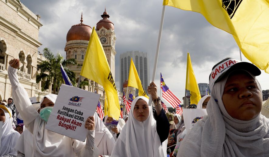 Thousands of protesters take a part in a rally to celebrate the government's move to withdraw plans to ratify a U.N. anti-discrimination convention at Independent Square in Kuala Lumpur, Malaysia, Saturday, Dec. 8, 2018. Thousands of Malaysian Muslims are rallying in Kuala Lumpur against any attempt to strip ethnic Malay majority of their privileges, in the first massive street gathering since Prime Minister Mahathir Mohamad's alliance won a historic vote in May.(AP Photo/Yam G-Jun)