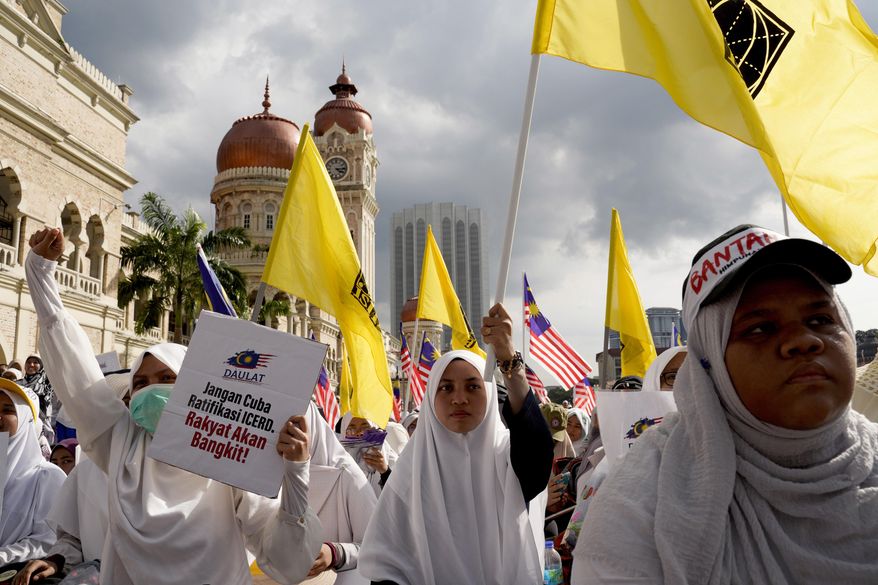 Thousands of protesters take a part in a rally to celebrate the government's move to withdraw plans to ratify a U.N. anti-discrimination convention at Independent Square in Kuala Lumpur, Malaysia, Saturday, Dec. 8, 2018. Thousands of Malaysian Muslims are rallying in Kuala Lumpur against any attempt to strip ethnic Malay majority of their privileges, in the first massive street gathering since Prime Minister Mahathir Mohamad's alliance won a historic vote in May.(AP Photo/Yam G-Jun)