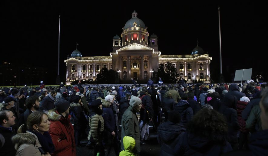 People march during a protest in front of the Serbian Parliament building in Belgrade, Serbia, Saturday, Dec. 8, 2018. Thousands of people are marching in Serbia against the hardline rule of President Aleksandar Vucic and his government. (AP Photo/Darko Vojinovic)