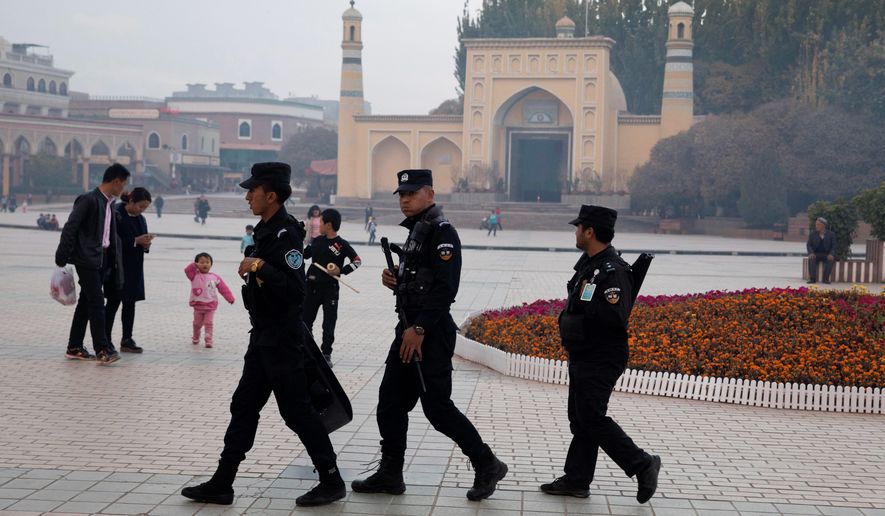 In this Nov. 4, 2017 photo, Uighur security personnel patrol near the Id Kah Mosque in Kashgar in western China&#39;s Xinjiang region. Authorities are using detentions in political indoctrination centers and data-driven surveillance to impose a digital police state in the region of Xinjiang and its Uighurs, a 10-million strong, Turkic-speaking Muslim minority Beijing fears could be influenced by extremism. (AP Photo/Ng Han Guan)