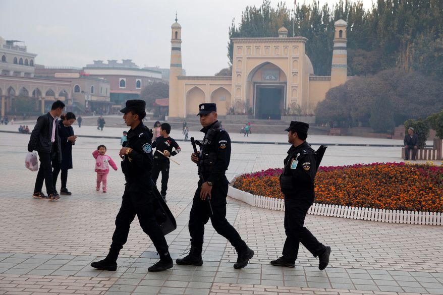 In this Nov. 4, 2017 photo, Uighur security personnel patrol near the Id Kah Mosque in Kashgar in western China&#39;s Xinjiang region. Authorities are using detentions in political indoctrination centers and data-driven surveillance to impose a digital police state in the region of Xinjiang and its Uighurs, a 10-million strong, Turkic-speaking Muslim minority Beijing fears could be influenced by extremism. (AP Photo/Ng Han Guan)