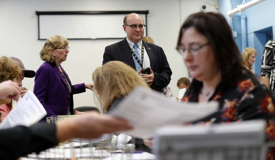 Secretary of State Matt Dunlap oversees the recounting of ballots in Maine's 2nd Congressional District, Thursday, Dec. 6, 2018, in Augusta, Maine. The recount was requested by outgoing U.S. Rep. Bruce Poliquin after losing a November ranked-choice race to Rep.-elect Jared Golden. (AP Photo/Robert F. Bukaty)