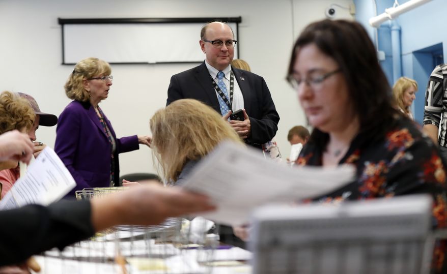 Secretary of State Matt Dunlap oversees the recounting of ballots in Maine's 2nd Congressional District, Thursday, Dec. 6, 2018, in Augusta, Maine. The recount was requested by outgoing U.S. Rep. Bruce Poliquin after losing a November ranked-choice race to Rep.-elect Jared Golden. (AP Photo/Robert F. Bukaty)