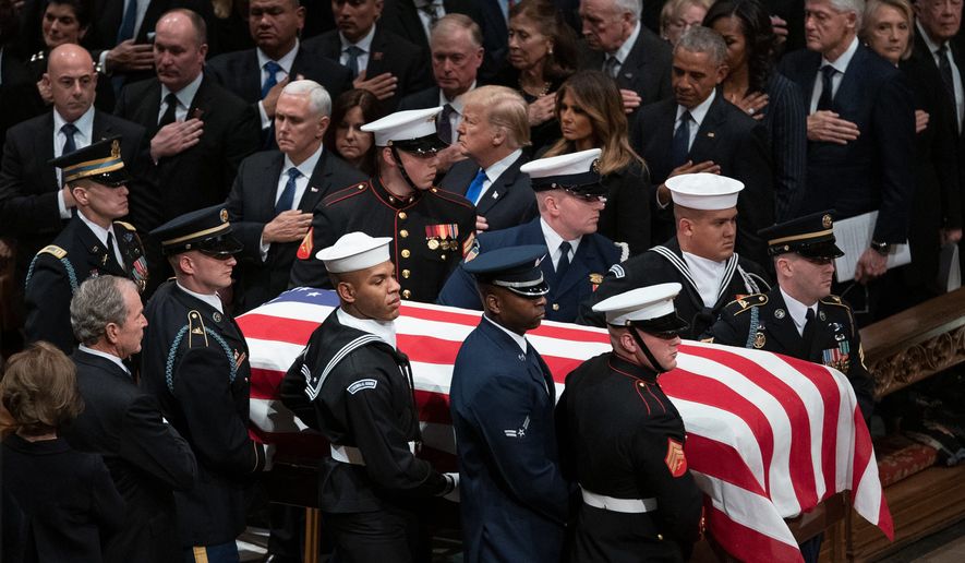 The flag-draped casket of former President George H.W. Bush is carried by a military honor guard past former presidents and first ladies George W. Bush and wife Laura Bush, President Donald Trump, first lady Melania Trump, former President Barack Obama, Michelle Obama, former President Bill Clinton, former Secretary of State Hillary Clinton and former President Jimmy Carter during a State Funeral at the National Cathedral, Wednesday, Dec. 5, 2018, in Washington. (AP Photo/Carolyn Kaster)