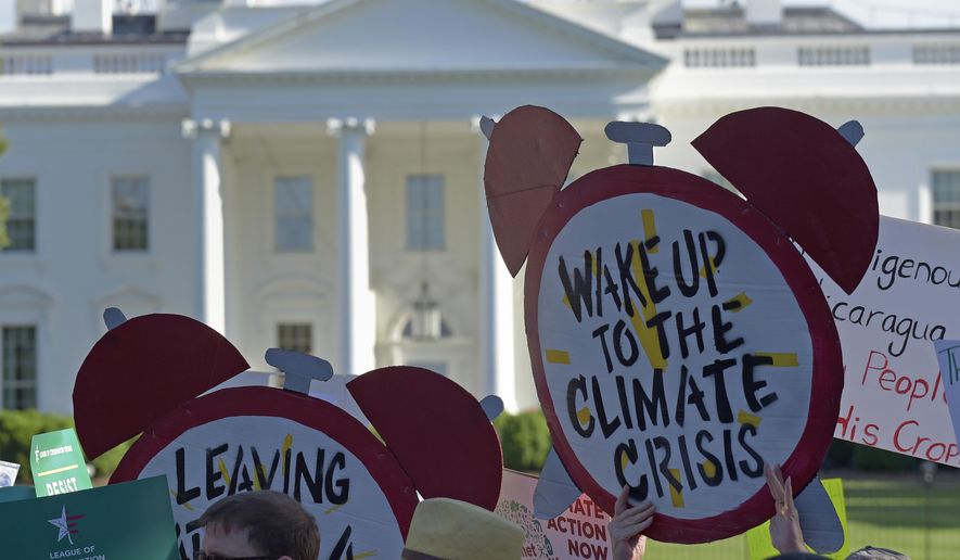In this June 1, 2017 file photo, protesters gather outside the White House in Washington to protest President Donald Trump's decision to withdraw the Unites States from the Paris climate change accord. On March 28, 2019, the first meeting of a new House Select Committee on the Climate Crisis convened, a new congressional panel established by the Democratic Congress to work on climate-change legislative issues. (AP Photo/Susan Walsh)