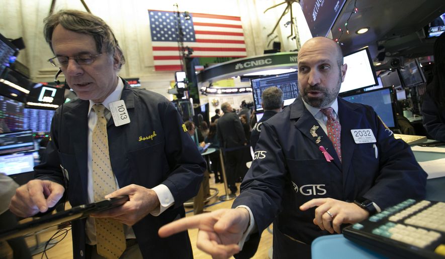 James Denaro, right, talks stock prices at the New York Stock Exchange, Monday, Dec. 10, 2018. (AP Photo/Mark Lennihan)
