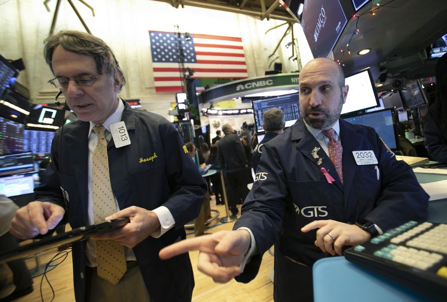 James Denaro, right, talks stock prices at the New York Stock Exchange, Monday, Dec. 10, 2018. (AP Photo/Mark Lennihan)