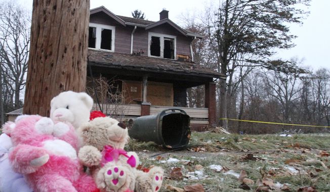 Stuffed animals rest against a pole at a makeshift memorial after a deadly fire in Youngstown, Ohio, Monday, Dec. 10, 2018. Authorities report that several children died in the fire. (William D. Lewis/The Vindicator via AP)