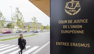 In this file photo taken on Monday, Oct. 5, 2015 a woman walks by the entrance to the European Court of Justice in Luxembourg. (AP Photo/Geert Vanden Wijngaert)  **FILE**