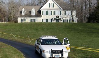 FILE - In this Dec. 18, 2012, file photo, a police cruiser sits in the driveway of the home of Nancy Lanza in Newtown, Conn., the Colonial-style house where she had lived with her son Adam Lanza. Documents from the investigation into the massacre at Sandy Hook Elementary School are shedding light on the Lanza’s anger, scorn for other people, and deep social isolation in the years leading up to the shooting. He fatally shot his mother there before driving to the school and ultimately killed himself. (AP Photo/Jason DeCrow, File)