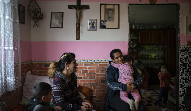 In this Nov. 14, 2018, photo, Monika Krcova, center left, sits with her daughter Ivana and her grandchildren in their house in Podhorany village, near Kezmarok, Slovakia. Krcova is no longer afraid of her local hospital since she isn&#x27;t planning to have more children, but worries about her daughter Ivana, who says she also was slapped by nurses when she previously gave birth and is now pregnant. (AP Photo/Felipe Dana)