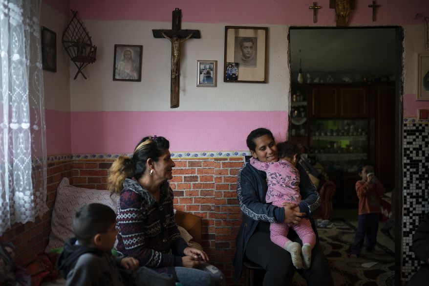 In this Nov. 14, 2018, photo, Monika Krcova, center left, sits with her daughter Ivana and her grandchildren in their house in Podhorany village, near Kezmarok, Slovakia. Krcova is no longer afraid of her local hospital since she isn&#x27;t planning to have more children, but worries about her daughter Ivana, who says she also was slapped by nurses when she previously gave birth and is now pregnant. (AP Photo/Felipe Dana)