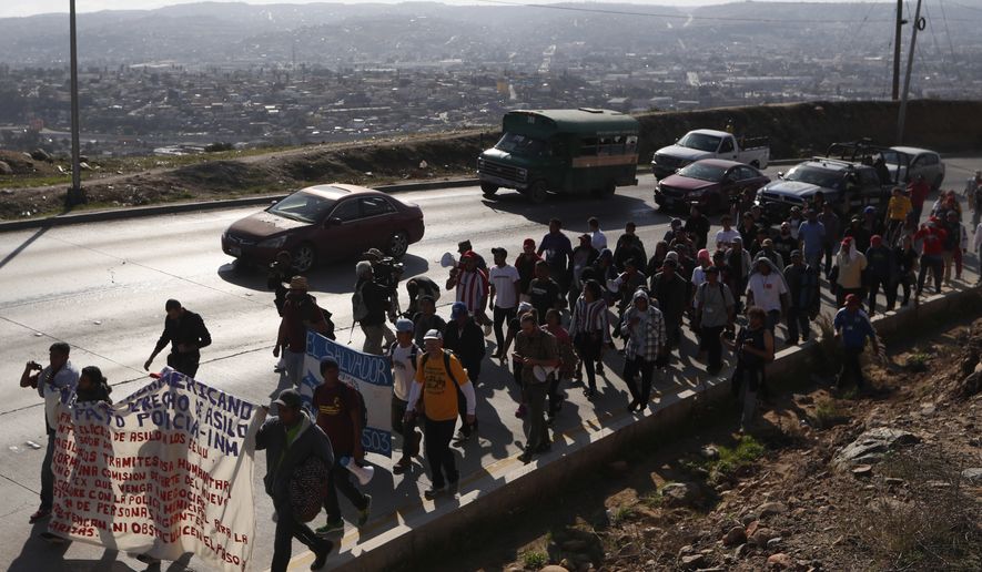 Central American migrants march to the U.S. consulate in Tijuana, Mexico, Tuesday, Dec. 11, 2018. Migrants want U.S. authorities to speed up the asylum application process for members of migrant caravans seeking to enter the U.S., including accepting more applications per day. (AP Photo/Moises Castillo)
