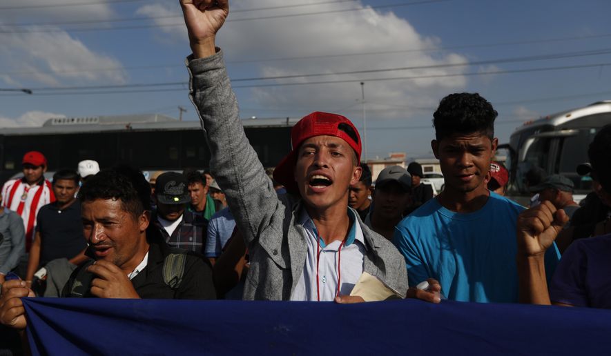 A Honduran migrant chants slogans during a demonstration outside the U.S. consulate in Tijuana, Mexico, Tuesday, Dec. 11, 2018. Migrants want U.S. authorities to speed up the asylum application process for members of migrant caravans seeking to enter the U.S., including accepting more applications per day. (AP Photo/Moises Castillo)
