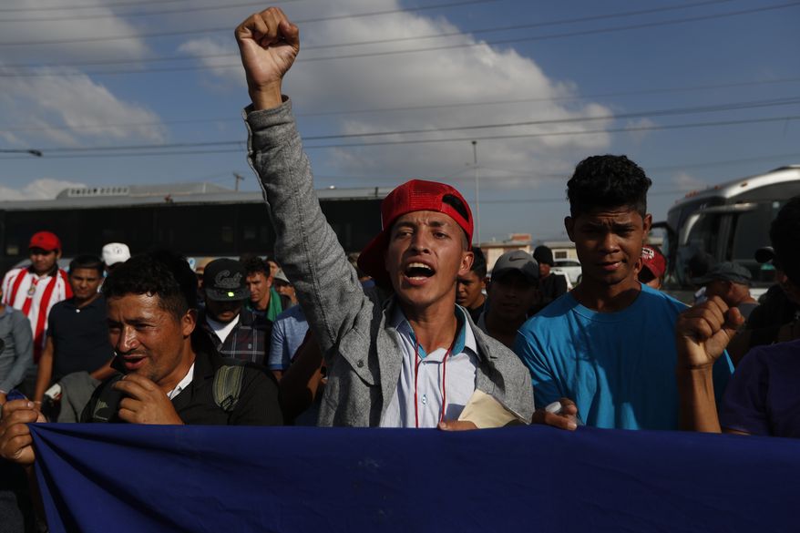 A Honduran migrant chants slogans during a demonstration outside the U.S. consulate in Tijuana, Mexico, Tuesday, Dec. 11, 2018. Migrants want U.S. authorities to speed up the asylum application process for members of migrant caravans seeking to enter the U.S., including accepting more applications per day. (AP Photo/Moises Castillo)