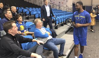 In this Dec. 4, 2018 photo, from left, Santa Cruz Warriors coach Aaron Miles visits with fans and sponsors after their basketball practice in Santa Cruz, Calif. As the Santa Cruz Warriors huddled together after practice, Darius Morris gave a quick recap of his adventure to the Arizona desert a day earlier to interview with the Suns. Phoenix needed a point guard with Devin Booker&#39;s hamstring injury, and Morris was in the mix. Coach Aaron Miles, who so wishes he were still playing, had to stand in leading the offense given Morris&#39; absence. Such is life in the topsy-turvy, changing-by-the-day G League, when Golden State or another club might come calling at a moment&#39;s notice to swipe a top player for promotion to the NBA. (AP Photo/Janie McCauley)
