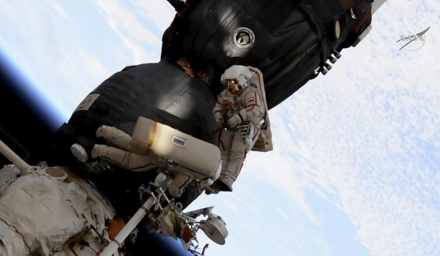 In this image from video made available by NASA, Russian cosmonaut Oleg Kononenko, right, and Sergei Prokopyev perform a spacewalk outside the Soyuz spacecraft attached to the International Space Station on Tuesday, Dec. 11, 2018. They are investigating a section where a mysterious leak appeared on Aug. 30. (NASA via AP)