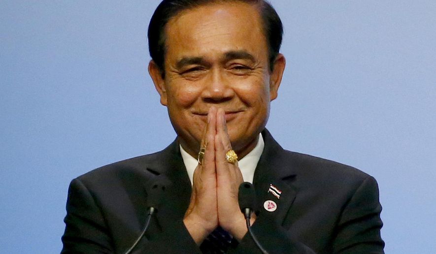 FILE - In this Nov. 15, 2018, file photo, Thai Prime Minister Prayuth Chan-ocha gestures the Thai way shortly after accepting the ASEAN Summit and Related Summits' hosting and chairmanship for next year in Thailand from Singaporean Prime Minister Lee Hsien Loong, in Singapore. Prayuth invoked a special executive power Tuesday, Dec. 11, 2018, to ease several restrictions that were set after the army seized power from an elected government. (AP Photo/Bullit Marquez, File)