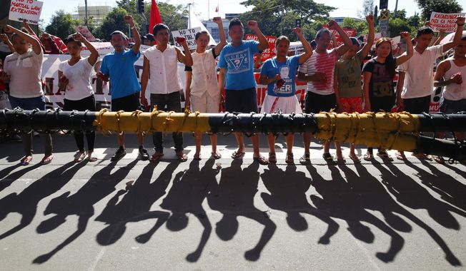 Protesters clench their fists during a rally at the Lower House to coincide with the joint Senate and Congress vote for the third extension of Martial Law in southern Philippines Wednesday, Dec. 12, 2018 in suburban Quezon city northeast of Manila, Philippines. In their statement, various opposition groups condemned the extension of Martial Law which allegedly will "lead to untimely death of more community leaders, human rights defenders, Indigenous Peoples, and Muslim opposition groups." (AP Photo/Bullit Marquez)