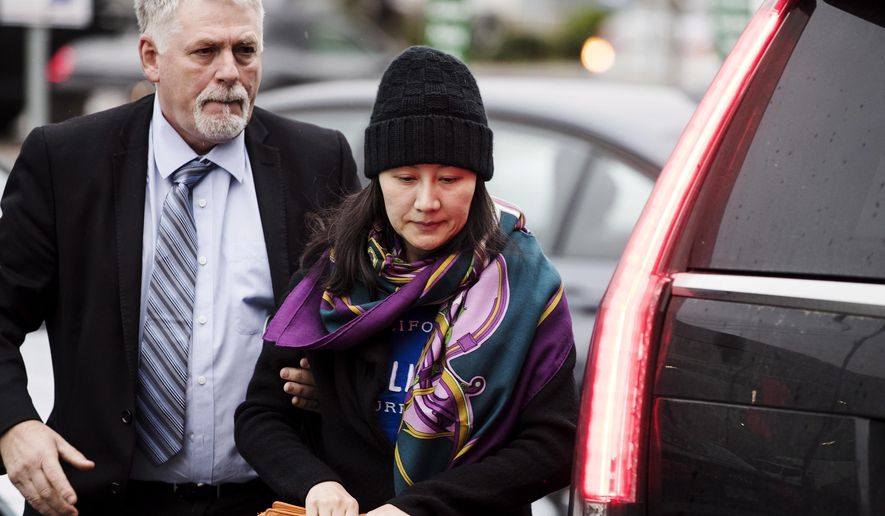 Huawei chief financial officer Meng Wanzhou arrives at a parole office with a security guard in Vancouver, British Columbia, Wednesday, Dec. 12, 2018. (Darryl Dyck/The Canadian Press via AP)