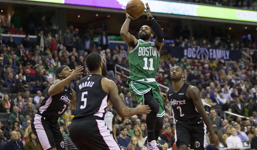 Boston Celtics guard Kyrie Irving (11) shoots between Washington Wizards guard Bradley Beal (3), forward Markieff Morris (5), and guard John Wall (2) during the overtime period of an NBA basketball game, Wednesday, Dec. 12, 2018, in Washington. The Celtics won 130-125. (AP Photo/Alex Brandon)