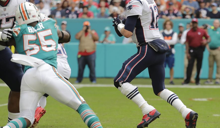 THIS CORRECTS THE IDENTIFICATION OF THE PATRIOTS PLAYER SHOWN TO QUARTERBACK TOM BRADY, AND NOT JULIAN EDELMAN - New England Patriots quarterback Tom Brady gets ready to throw a touchdown pass to wide receiver Julian Edelman (not shown), during the first half of an NFL football game against the Miami Dolphins, Sunday, Dec. 9, 2018, in Miami Gardens, Fla. (AP Photo/Lynne Sladky)