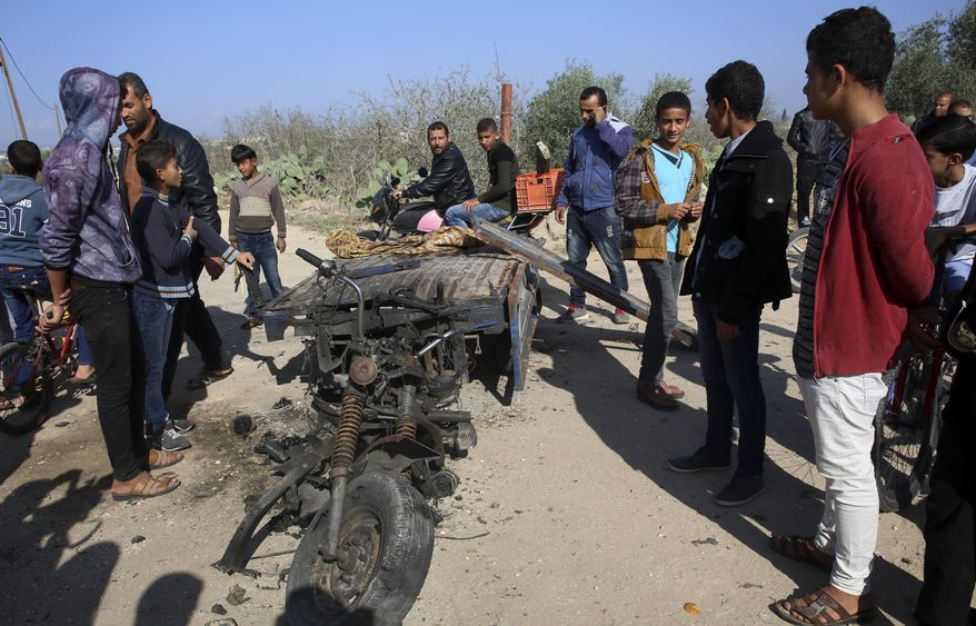 In this Monday, Nov. 12, 2018, file photo, Palestinians inspect a vehicle that was destroyed in an Israeli raid that killed seven Hamas Palestinian militants, including a local Hamas commander, late Sunday, east of Khan Younis, southern Gaza Strip. (AP Photo/Adel Hana, File)
