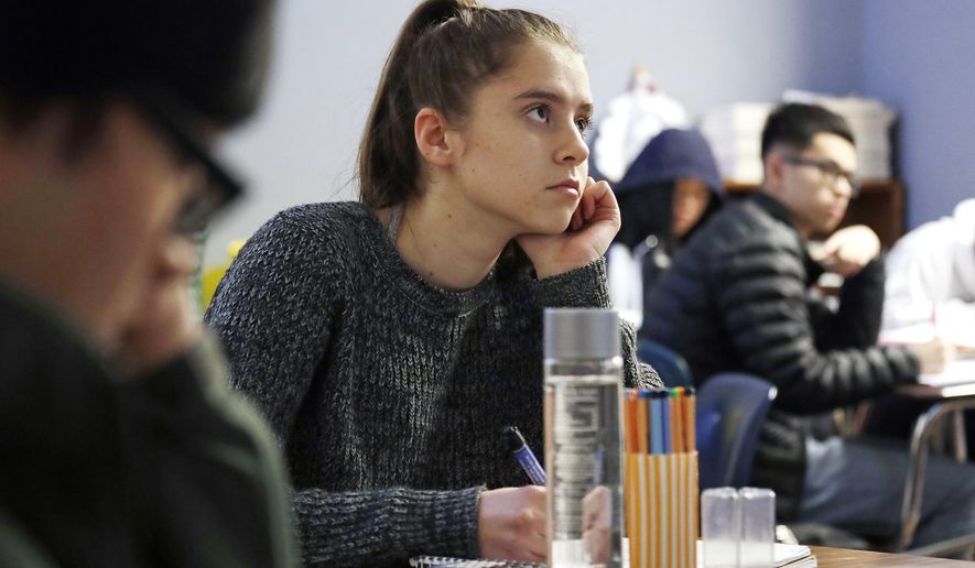 Senior Hazel Ostrowski attends her first period AP statistics class at Franklin High School Wednesday, Dec. 12, 2018, in Seattle. High school students are getting more sleep in Seattle, according to a study on later school start times. Ostrowski was among a group at Franklin and another Seattle high school who wore activity monitors to discover whether a later start to the school day would help them get more sleep. It did, adding 34 minutes of slumber a night, and they reported less daytime sleepiness and grades improved. (AP Photo/Elaine Thompson)