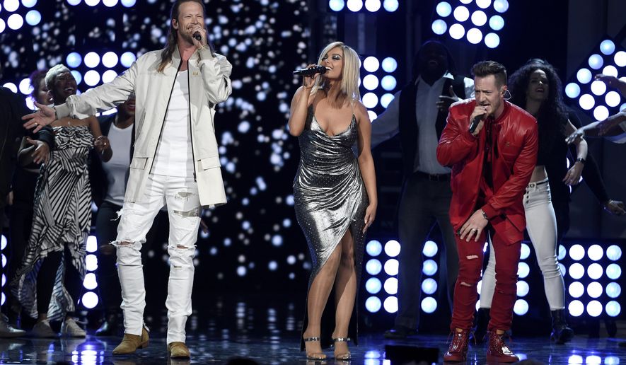 FILE - In this April 15, 2018 file photo, Tyler Hubbard, right, and Brian Kelley, left, of Florida Georgia Line, and Bebe Rexha, center, perform &amp;quot;Meant to Be&amp;quot; at the 53rd annual Academy of Country Music Awards in Las Vegas. The two are nominated for a Grammy Award with pop singer Bebe Rexha for best country duo/group performance for their chart busting hit of the year. (Photo by Chris Pizzello/Invision/AP, File)