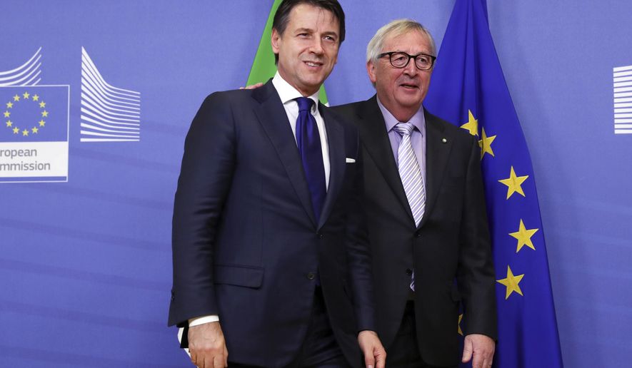 European Commission President Jean-Claude Juncker, right, greets Italian Prime Minister Giuseppe Conte prior to a meeting at EU headquarters in Brussels, Wednesday, Dec. 12, 2018. (Francisco Seco)