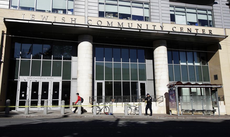 A police officer removes police tape along California Street in San Francisco, Thursday, Dec. 13, 2018. Authorities say bomb threats sent to dozens of schools, universities and other locations across the U.S. appear to be a hoax. (AP Photo/Jeff Chiu)